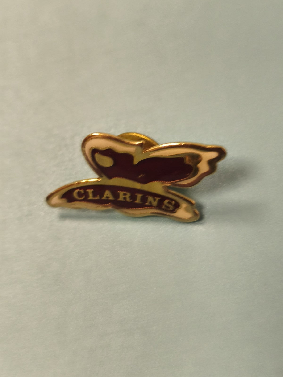 Pin's vintage Clarins papillon doré émaillé ancien collection publicitaire