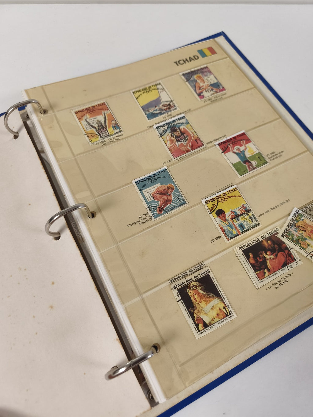 Classeur de timbres partiellement rempli Tchad, pages à anneaux, couverture bleu