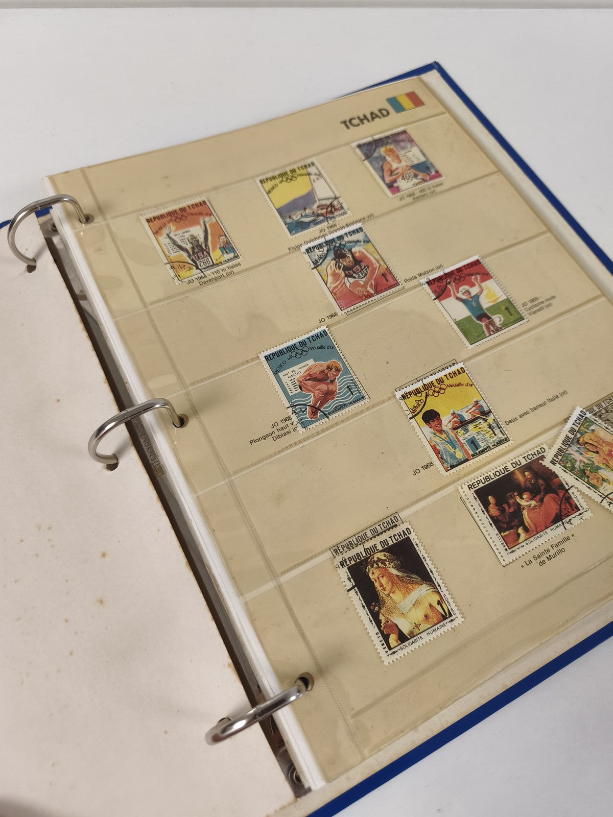 Classeur de timbres partiellement rempli Tchad, pages à anneaux, couverture bleu