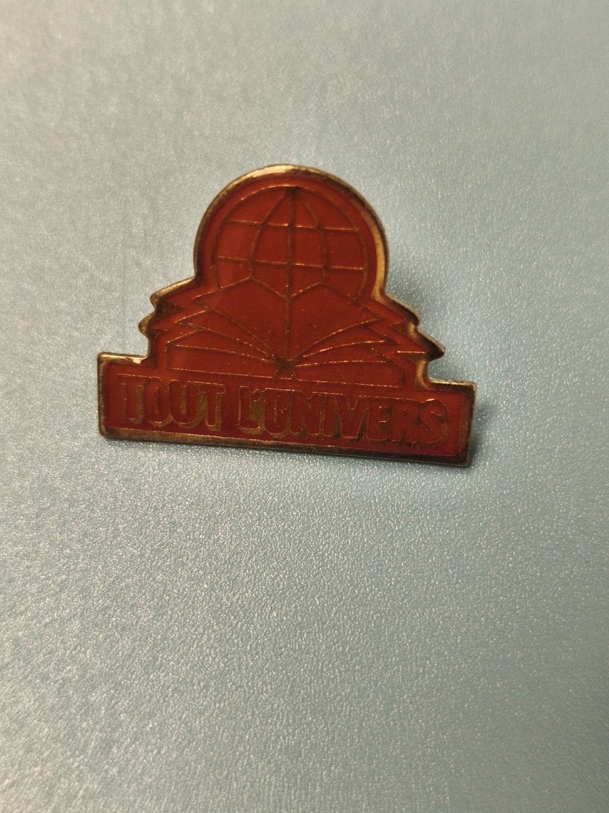 Pin's vintage Tout l'Univers rouge, globe et livre ouvert, collection (Ref 14)