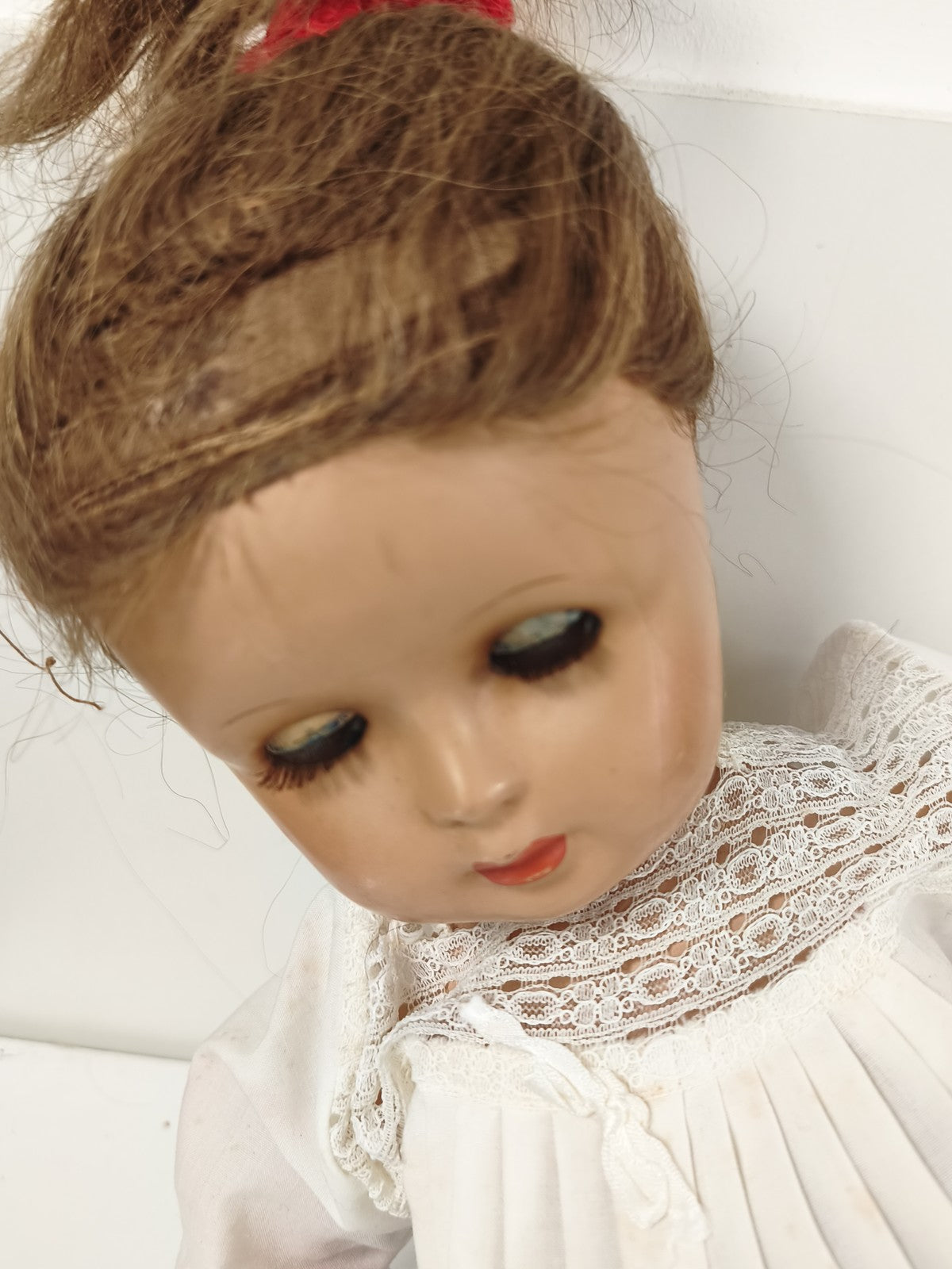 Poupée ancienne yeux dormeurs, tenue coton dentelle et chaussons tricot