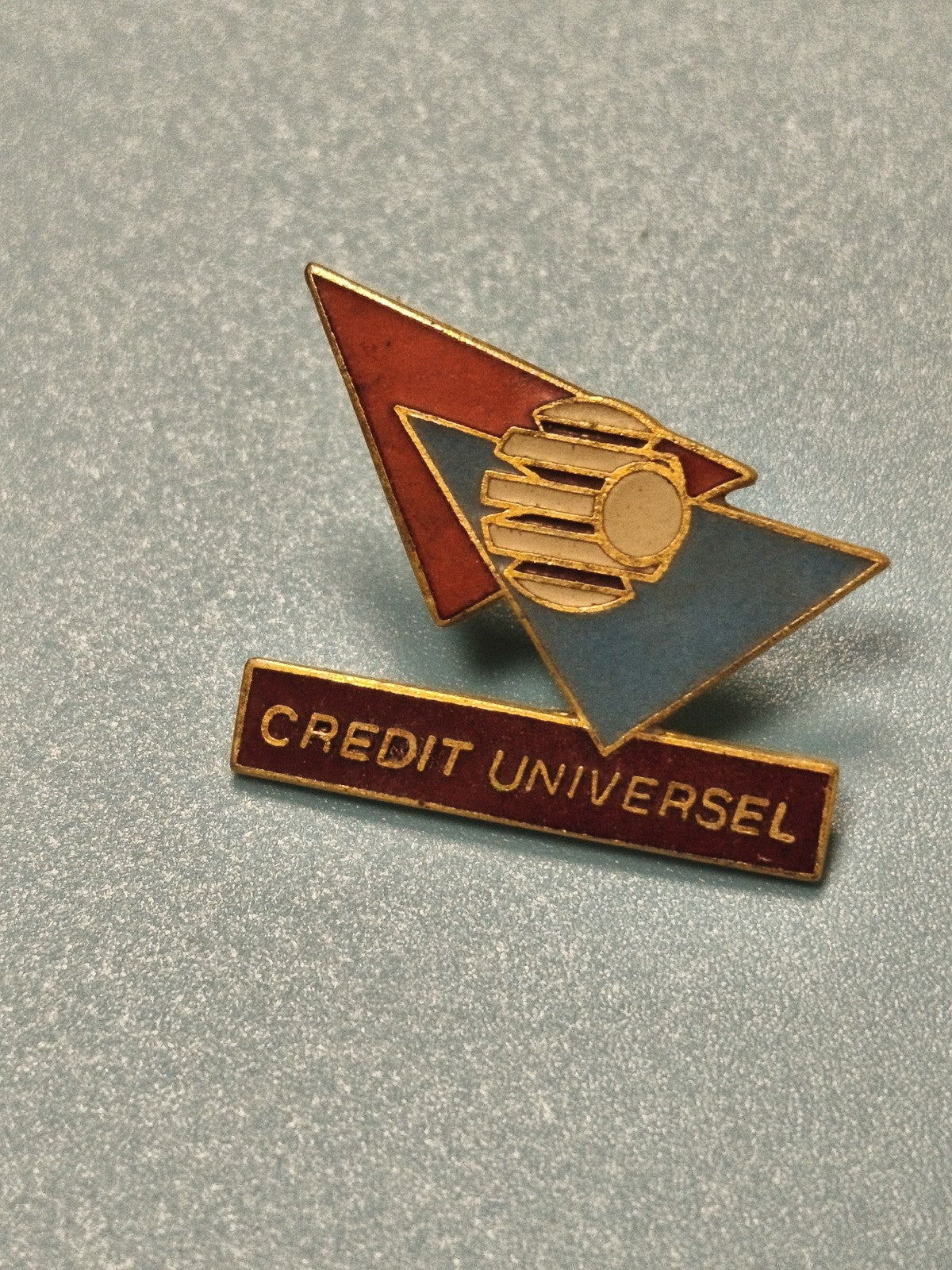 Vintage pin's Crédit Universel logo géométrique rouge bleu collection banque