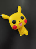 Figurine Funko Pop Pikachu Pokémon jaune, visage souriant, déco bureau