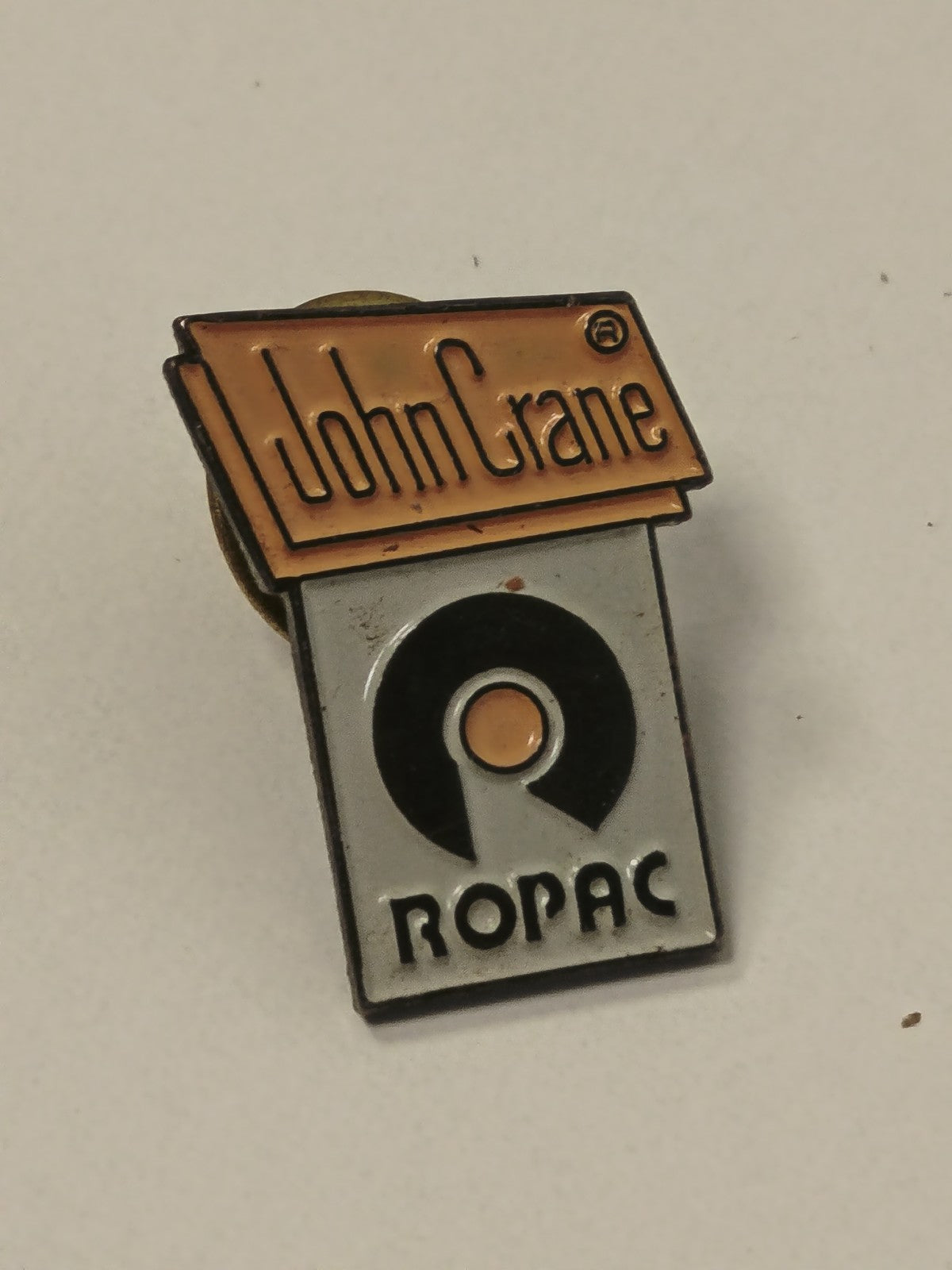 Pin's rétro ancien John Crane vintage badge collection objet publicitaire rare