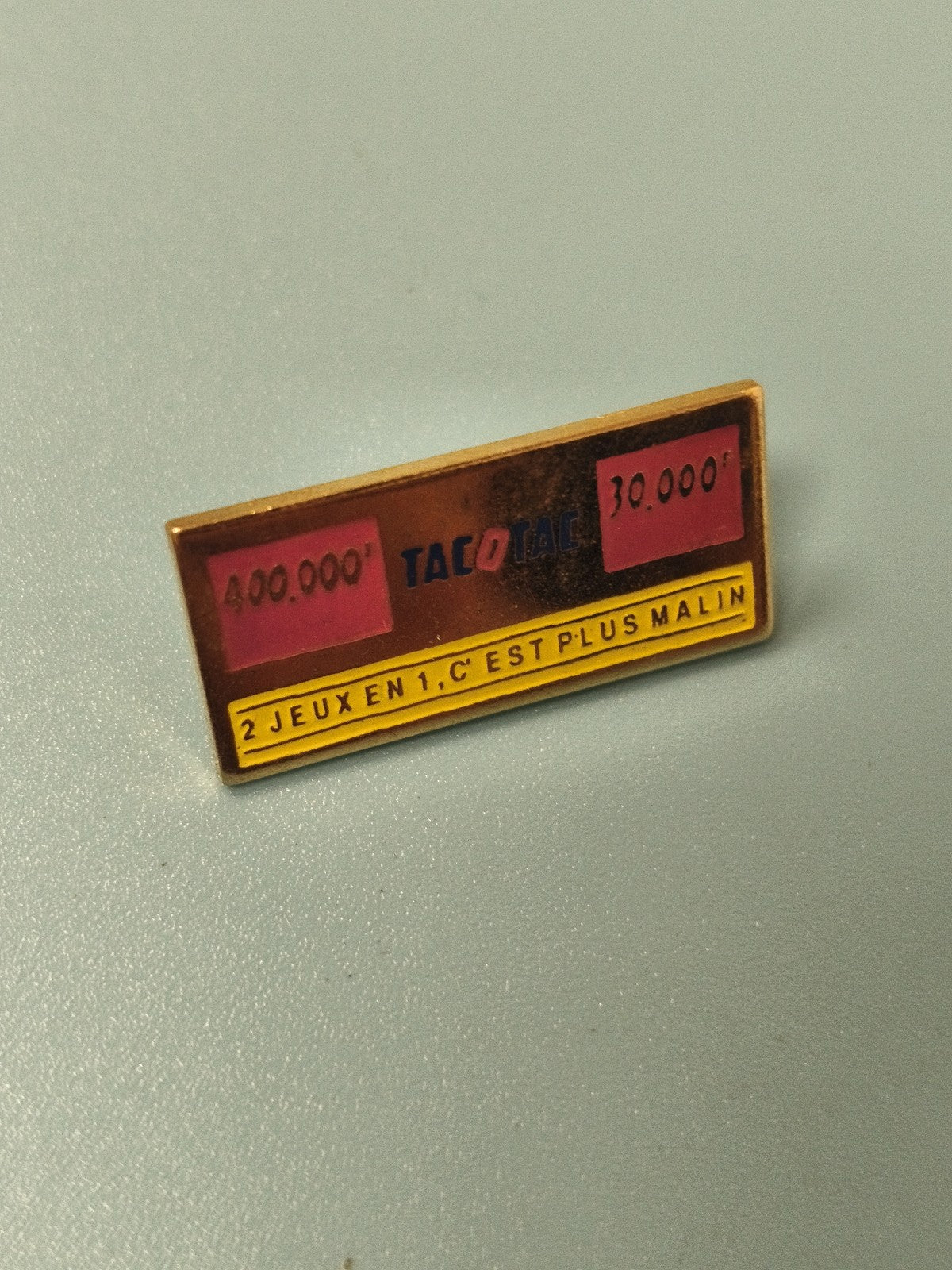 Vintage pin's publicitaire Tacotac rectangulaire rouge jaune ancien jeu loterie