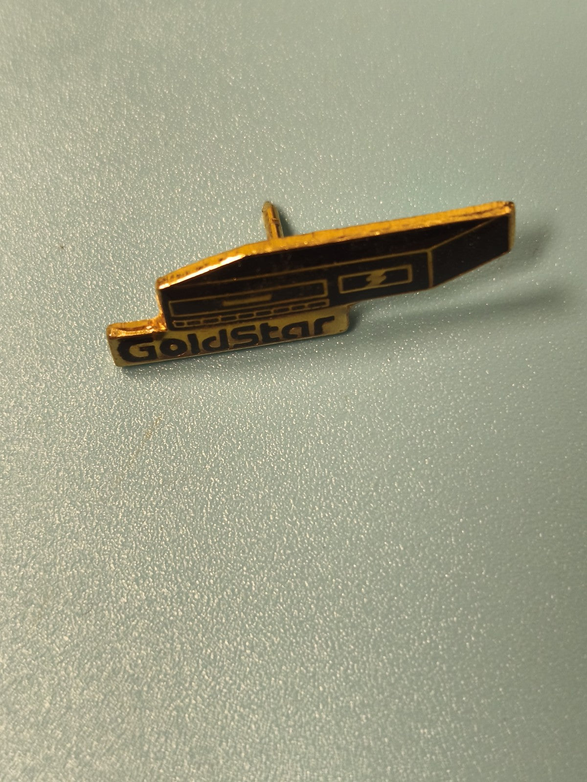 Pin's vintage GoldStar noir et doré, forme rétro, collection, occasion