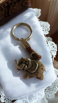 Porte-clés éléphant Selmy Trading vintage, aspect laiton, tressage cuir