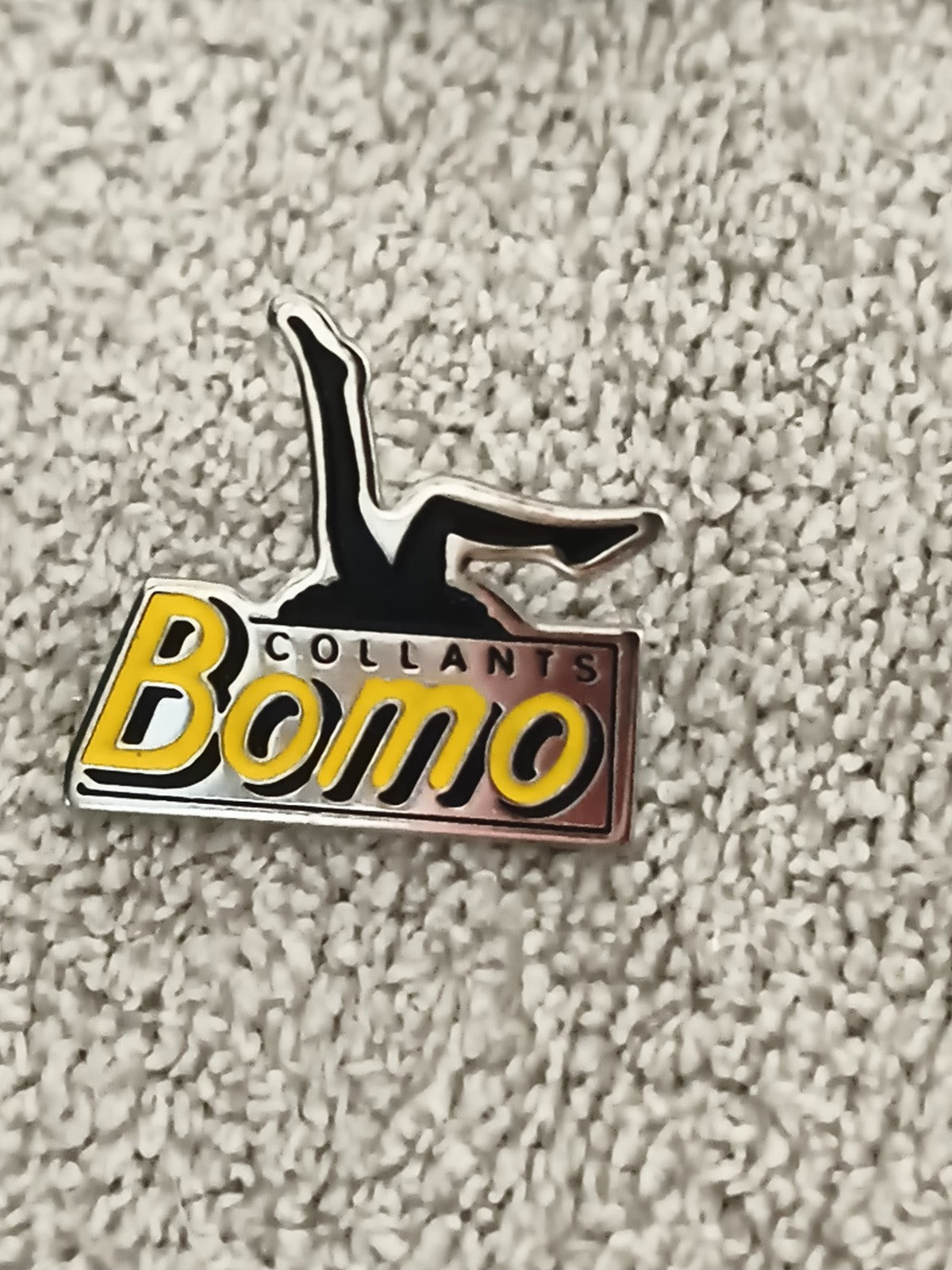 Pin's publicitaire vintage Collants Bomo logo jaune noir émail ancien (Ref 1)