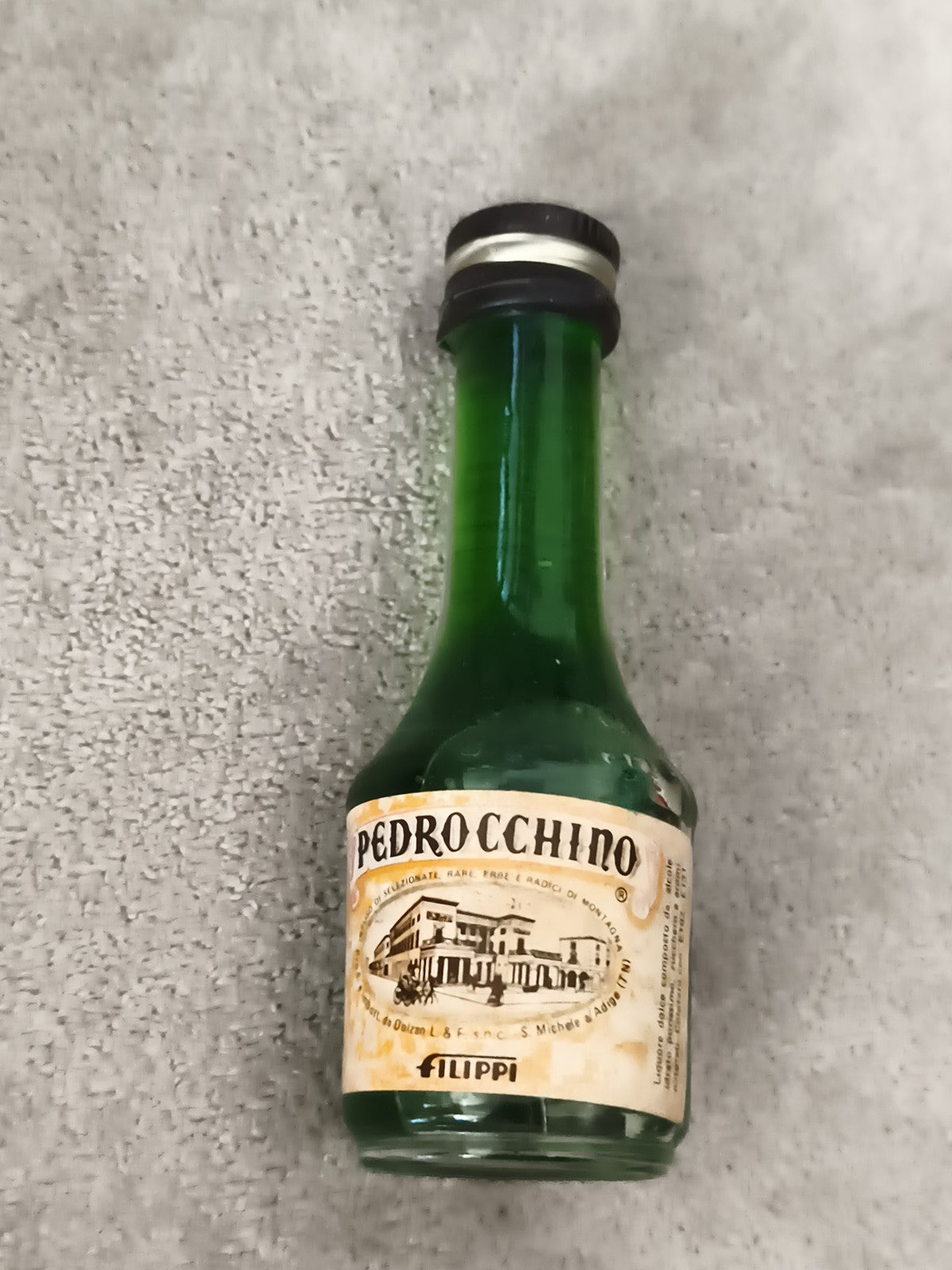 Mini-bouteille alcool Pedrocchino Filippi vert capsule noire partiellement rempl