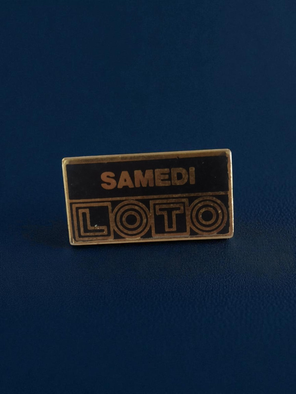 Pin's publicitaire Loto Samedi rétro noir doré années 90 vintage jeu hasard
