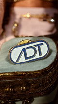 Pin's vintage ADT logo rétro années 90, badge émaillé blanc bleu