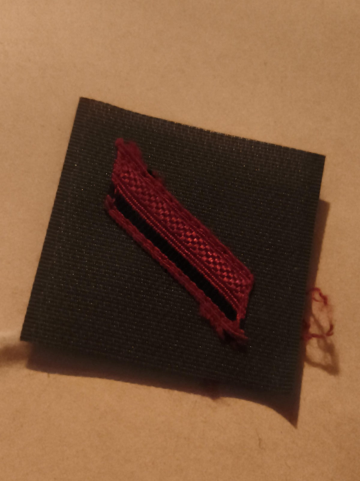 Insigne militaire ancien ruban rouge sur tissu noir décoration uniforme