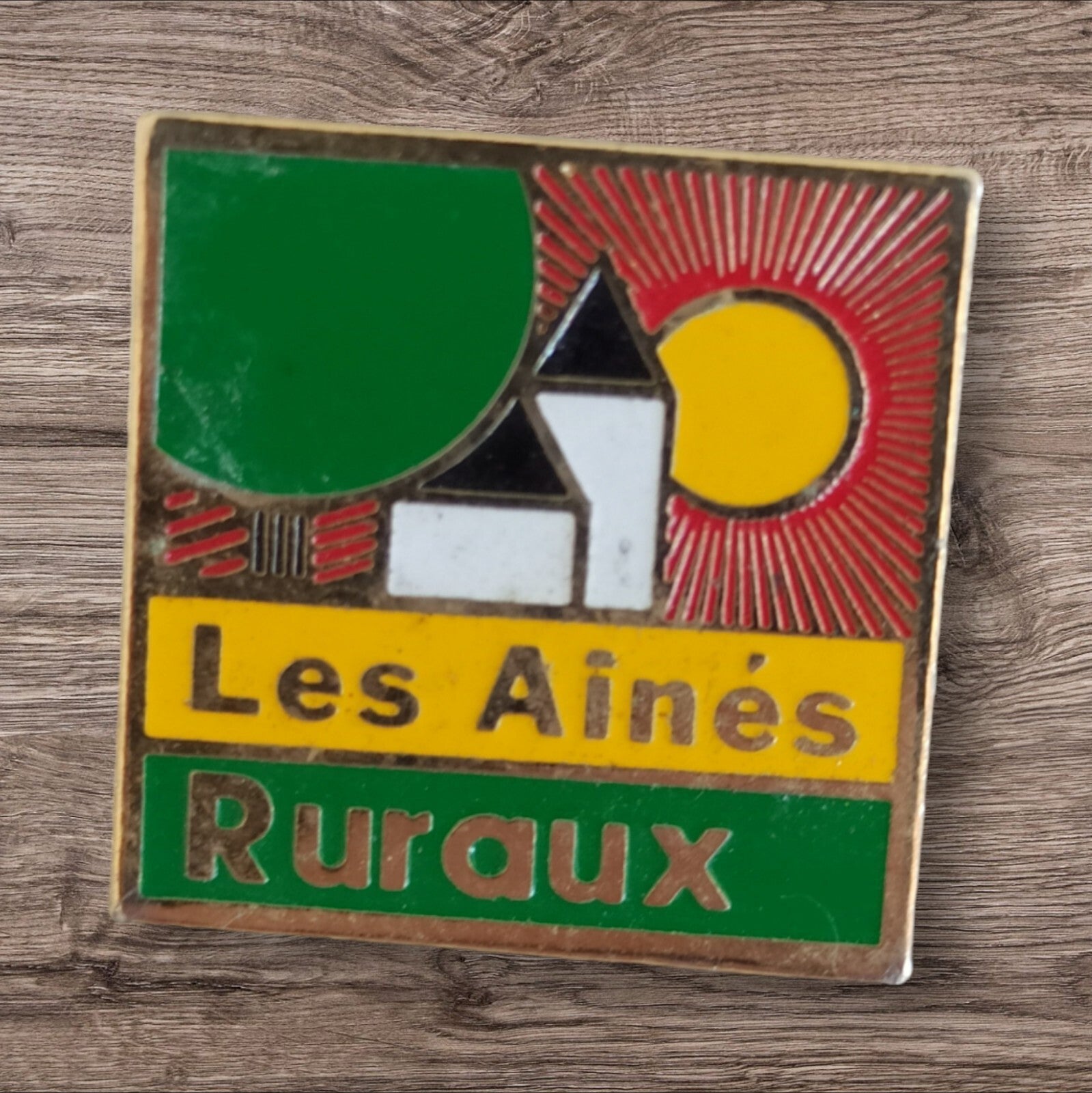 Pin's vintage Les Aînés Ruraux émail, logo église soleil, rare