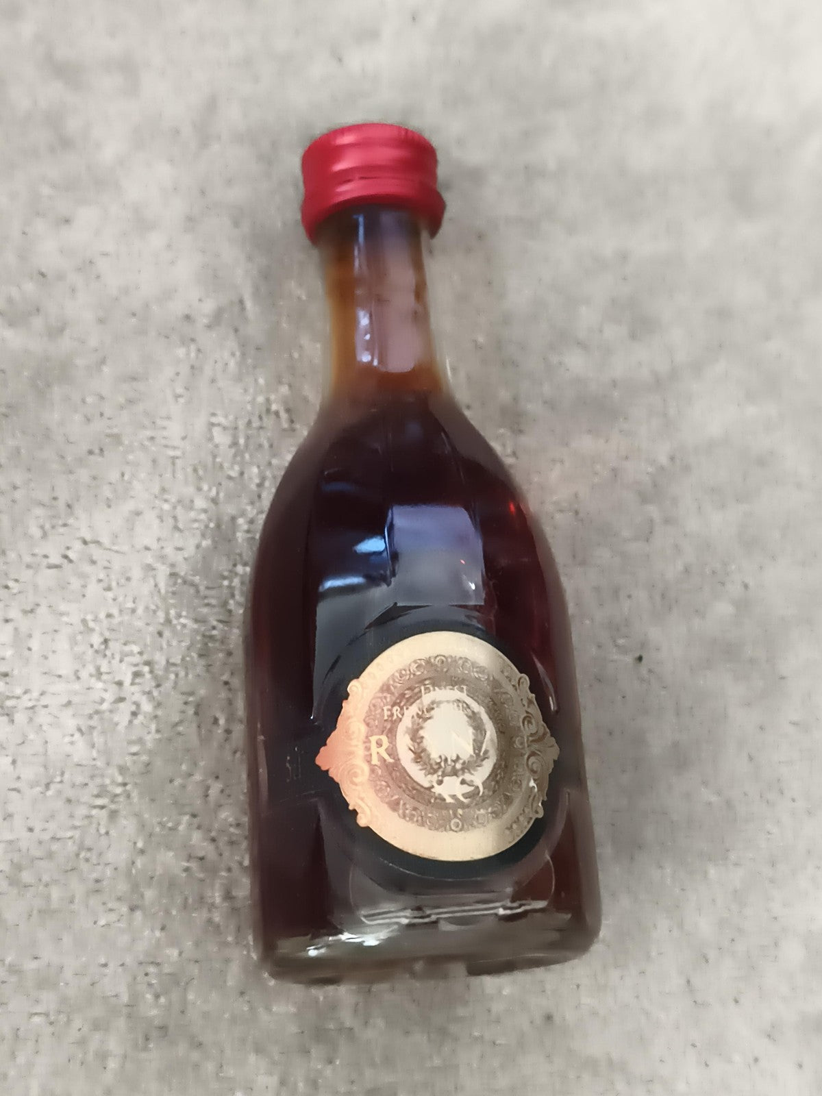 Miniature alcool bouteille décorative bouchon rouge partiellement remplie