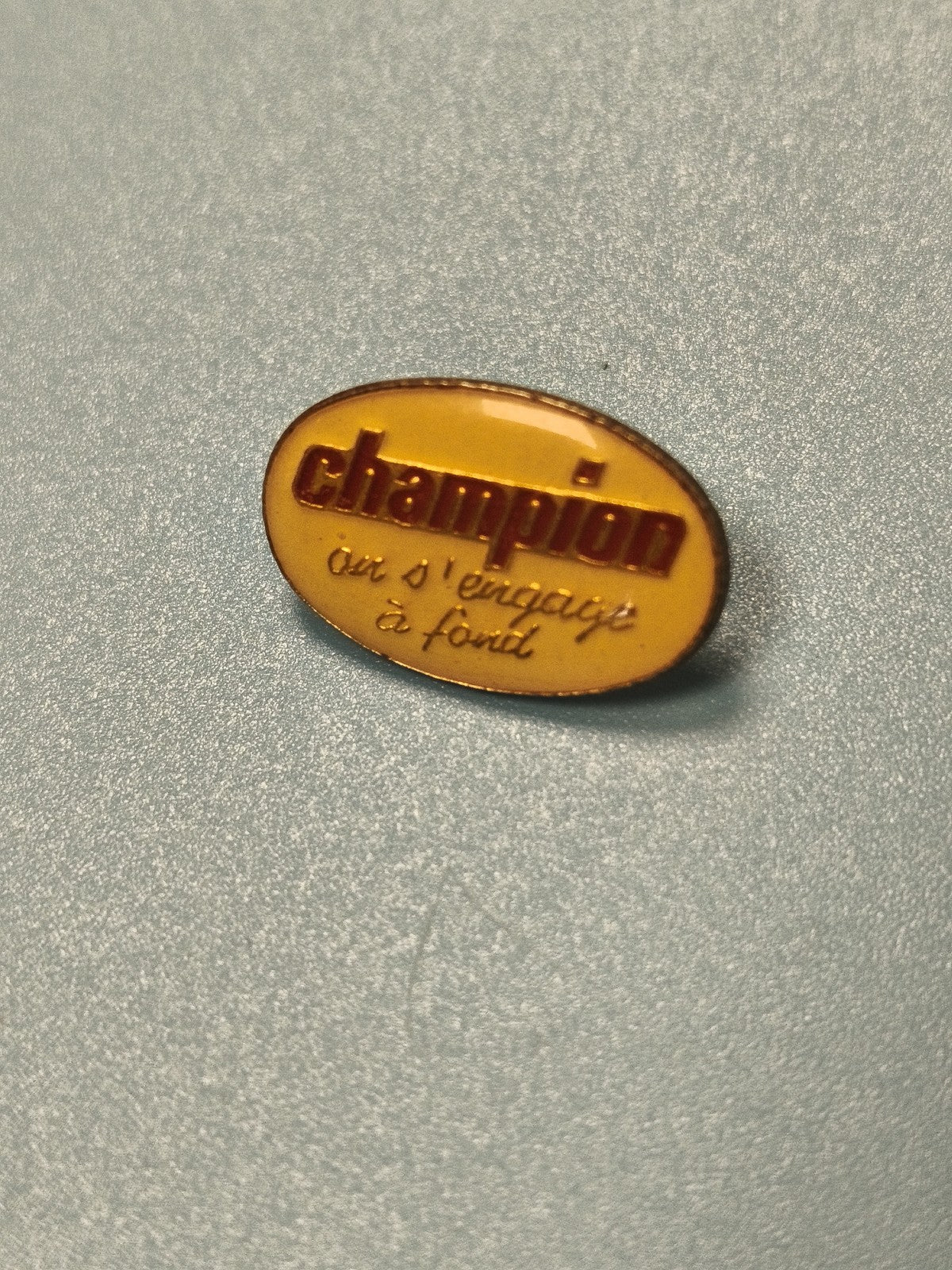 Vintage pin's Champion oval jaune ancien slogan collection (ref 11)