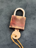 Cadenas ancien marbré avec clé, aspect métallique rétro, serrure vintage