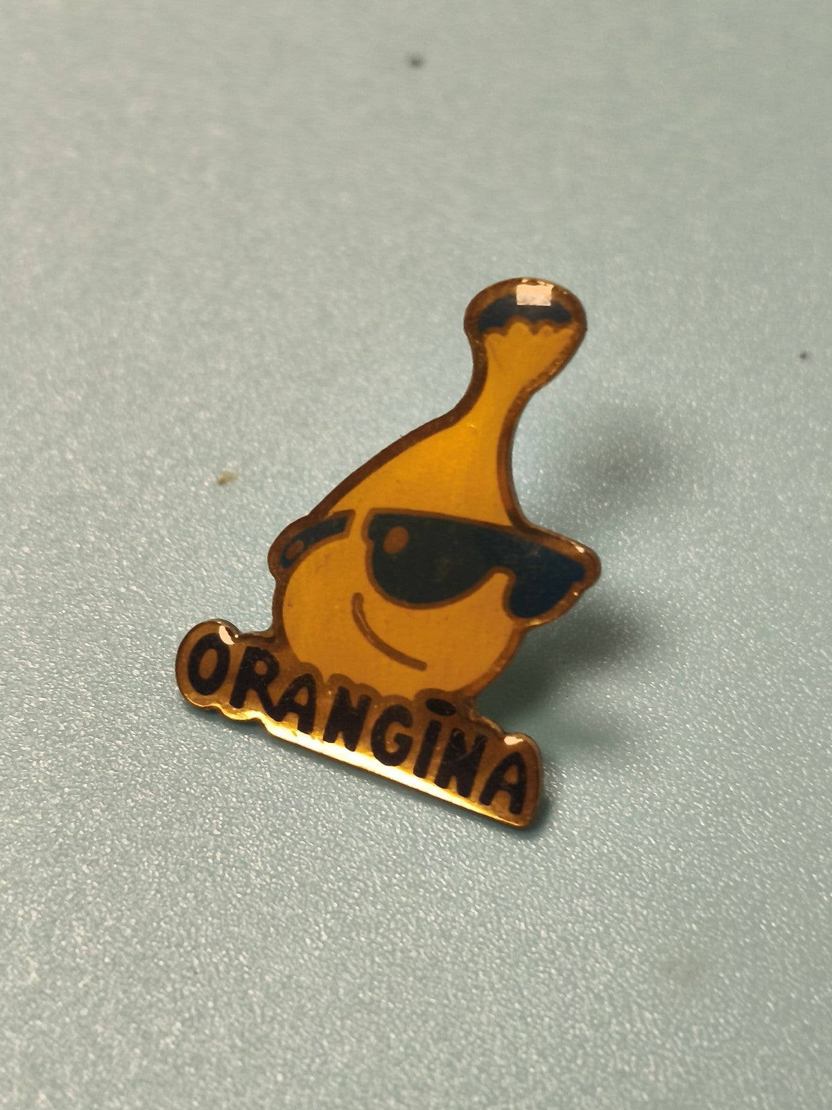 Pin's vintage Orangina publicitaire collection, logo bouteille jaune lunettes Re