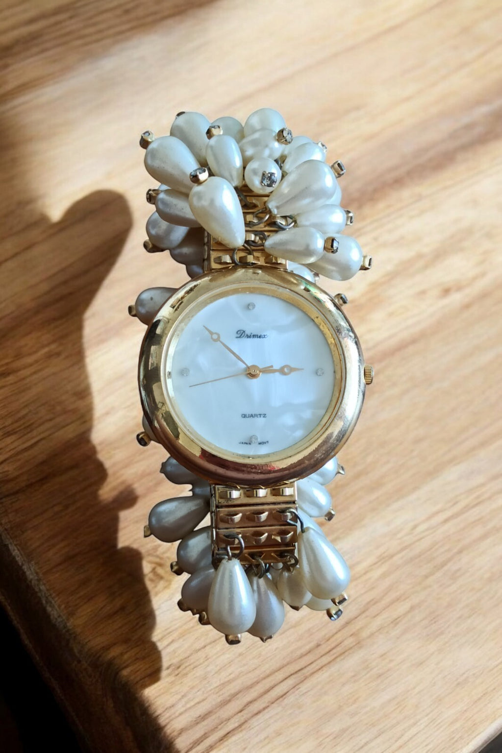 Montre femme Drimex bracelet perles nacrées doré cadran blanc élégant