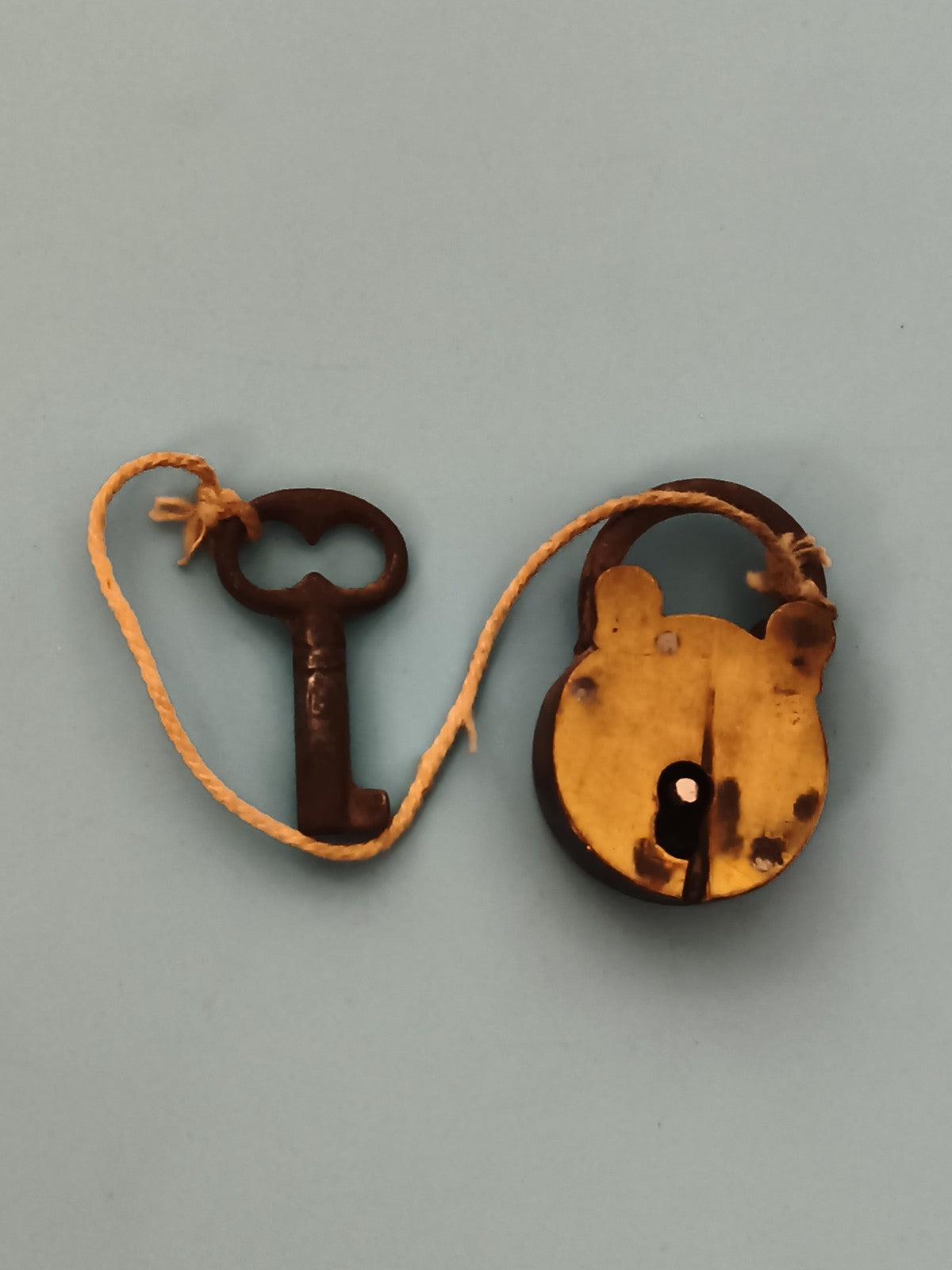 Ancien cadenas à clé, forme ronde, patine foncée, style vintage