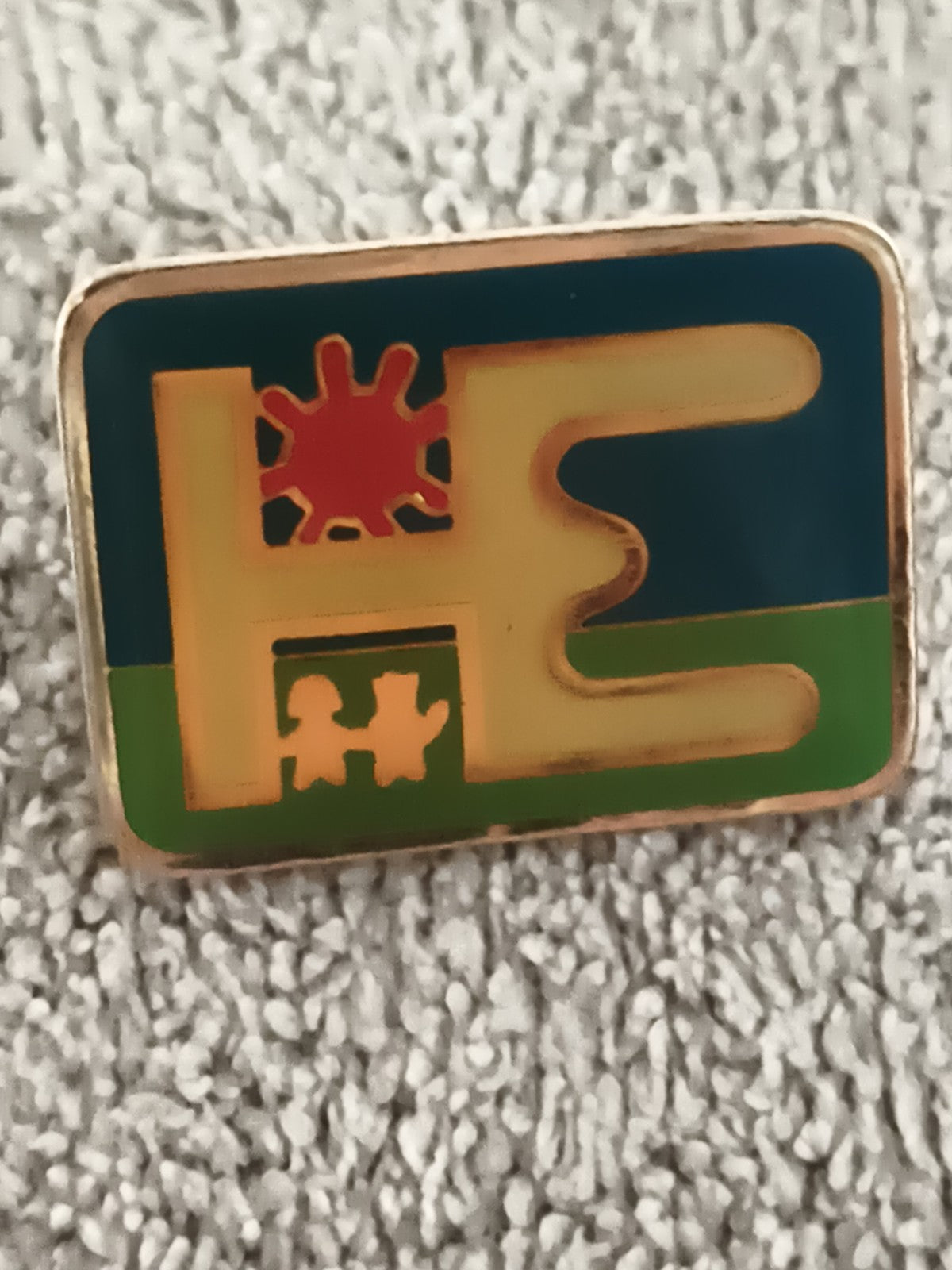 Pin's vintage HE logo soleil personnages émaillé rectangulaire (Ref 9)
