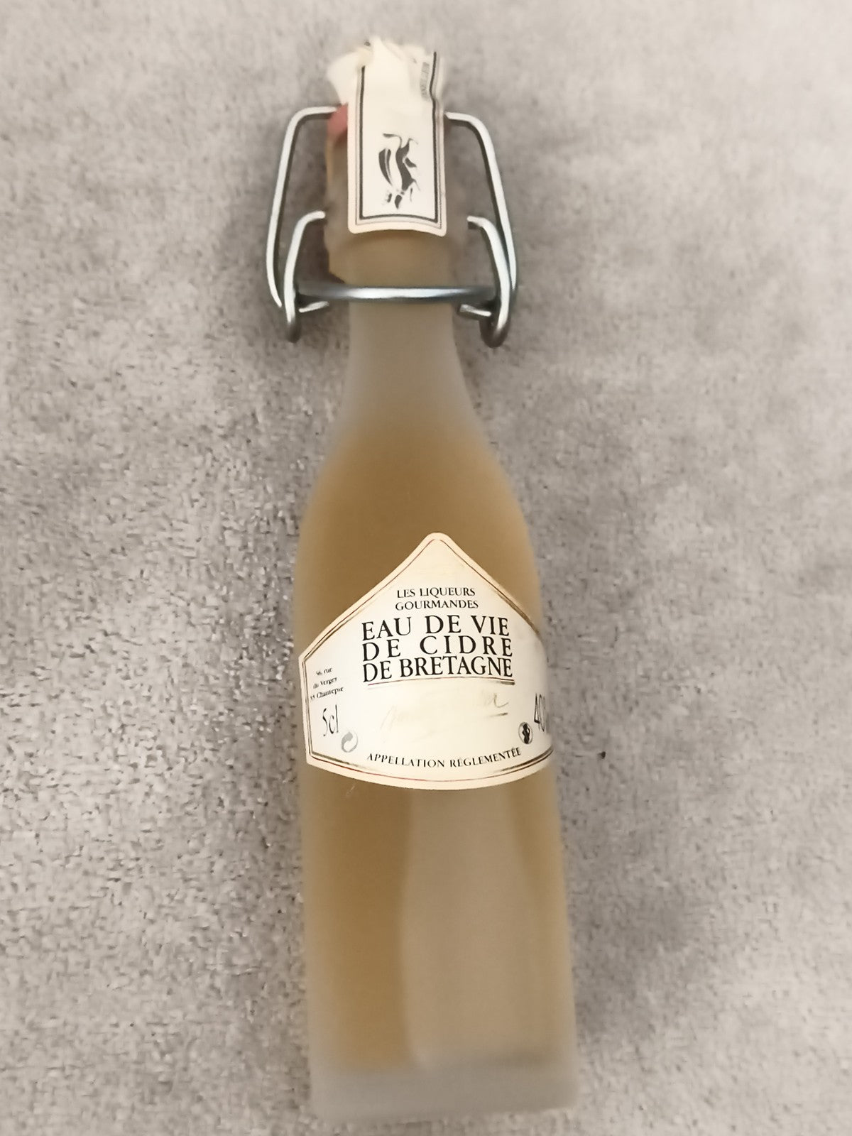 Mini bouteille eau de vie de cidre Bretagne partiellement remplie liqueur