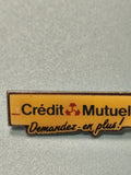 Pin's vintage Crédit Mutuel jaune slogan Demandez-en plus banque ancienne pub