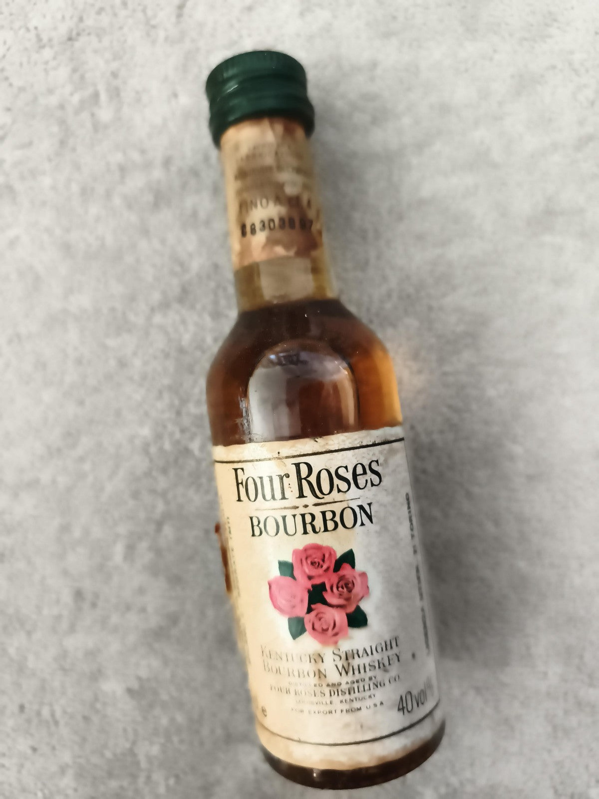 Miniature whisky Four Roses Bourbon bouteille décor rose partiellement remplie