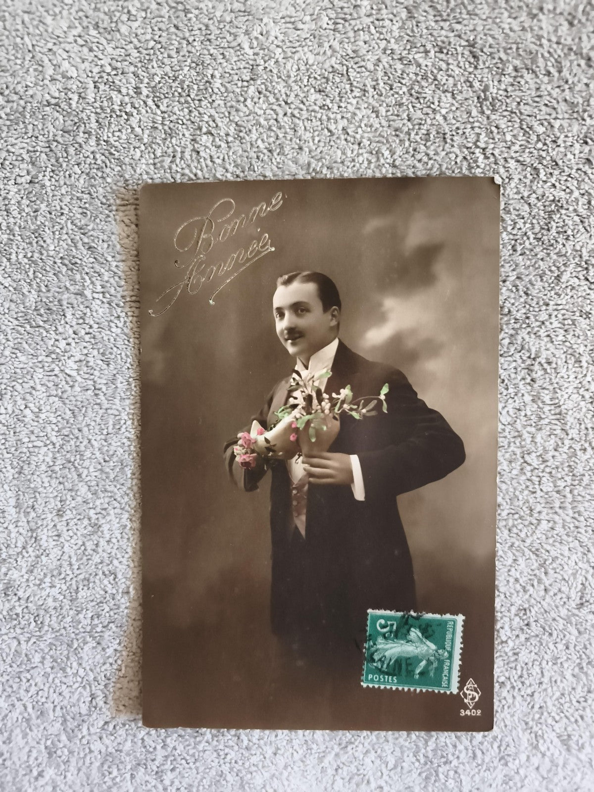 CPA Bonne Année homme bouquet costume timbre vert début XXe photo sépia