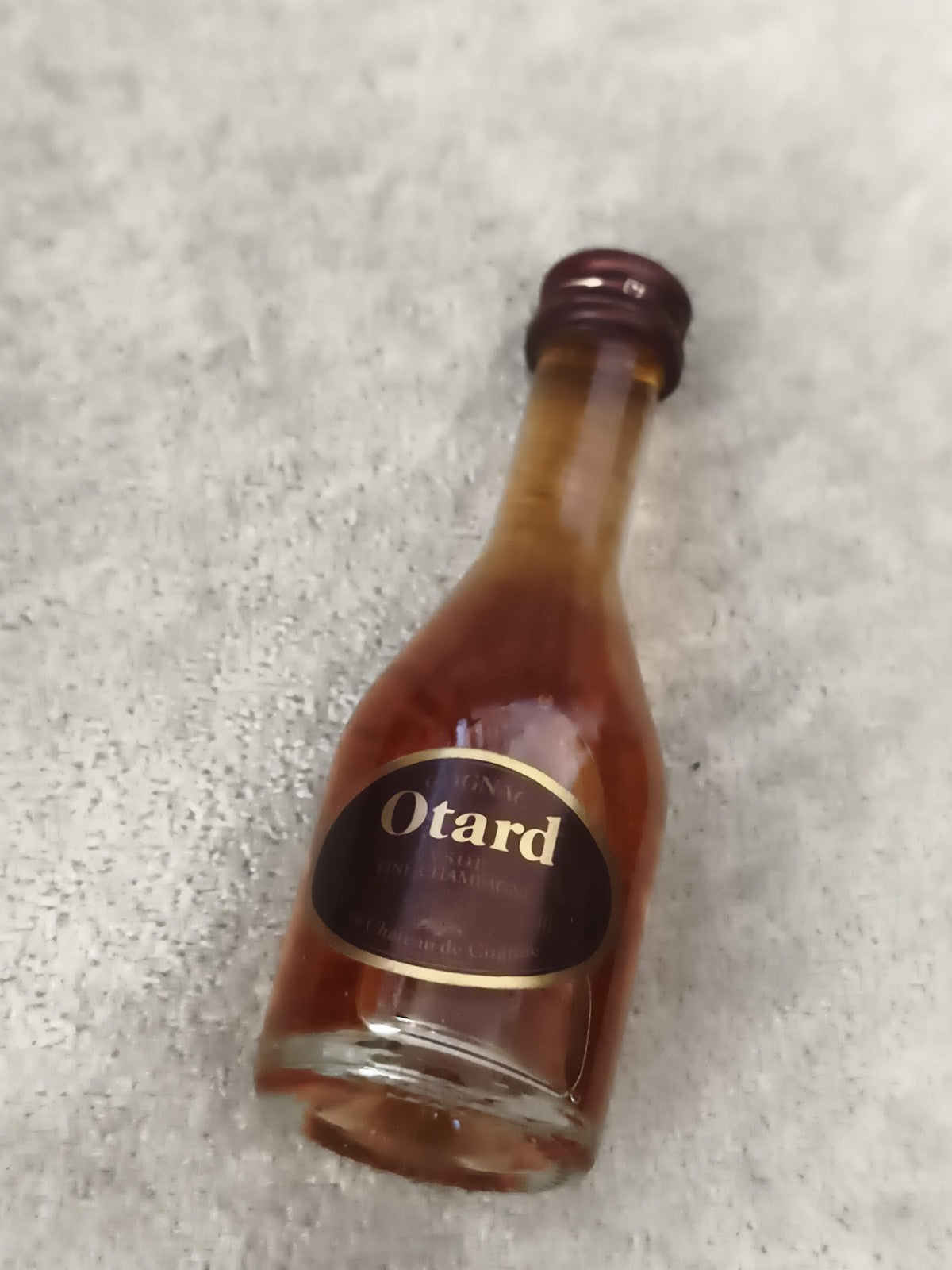 Miniature cognac Otard bouteille verre étiquette noire partiellement remplie