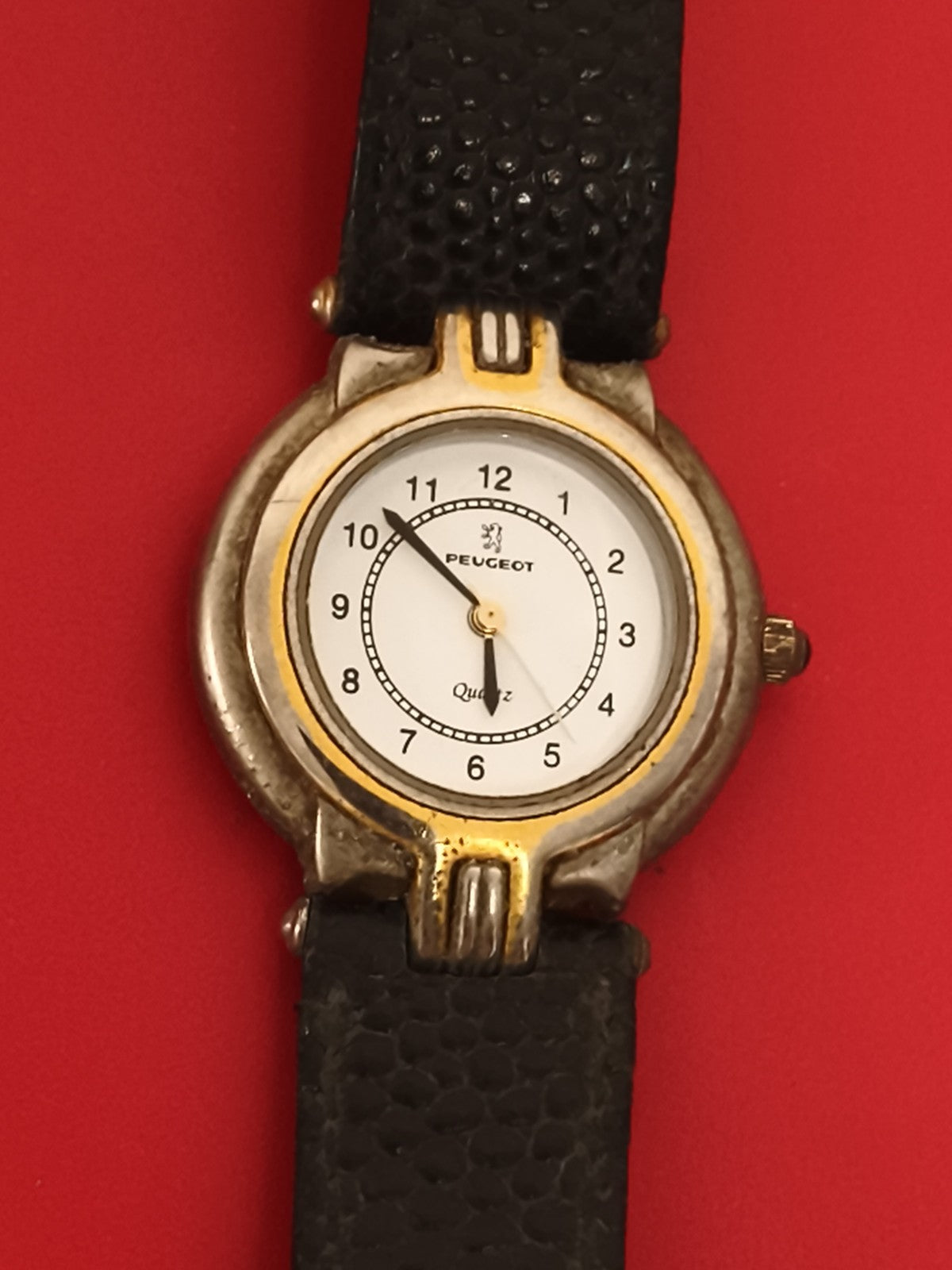 Montre ancienne Peugeot quartz publicitaire, cadran blanc, bracelet noir vintage