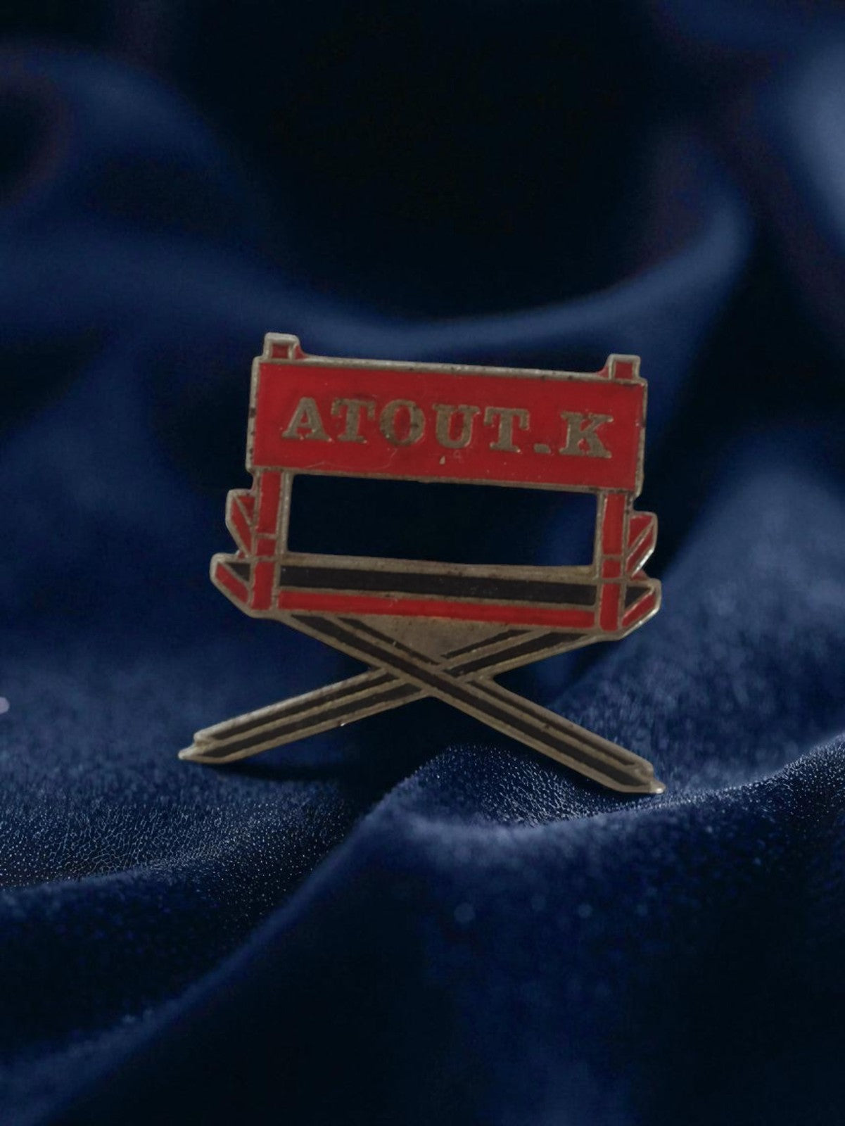 Pin's publicitaire vintage ATOUT K forme chaise réalisateur badge rétro