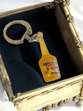 Porte-clés vintage bouteille alcool jaune publicitaire France rétro