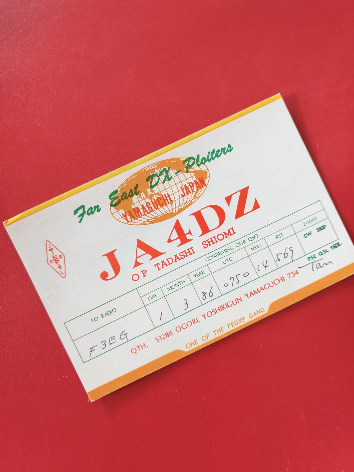 Carte radio QSL JA4DZ Japon Yamaguchi ? Opérateur Tadashi Shiomi, fond rouge