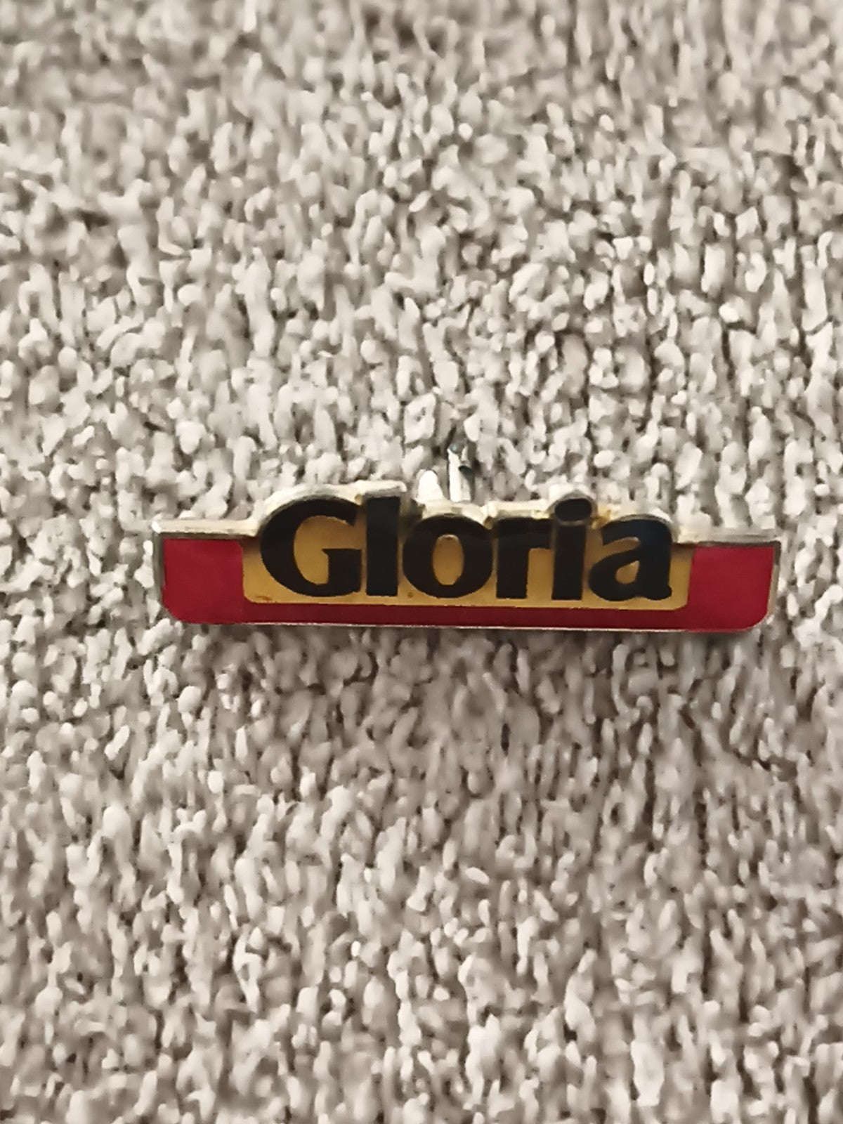 Pin's publicitaire vintage Gloria, lettrage noir sur fond rouge jaune (Ref 5)