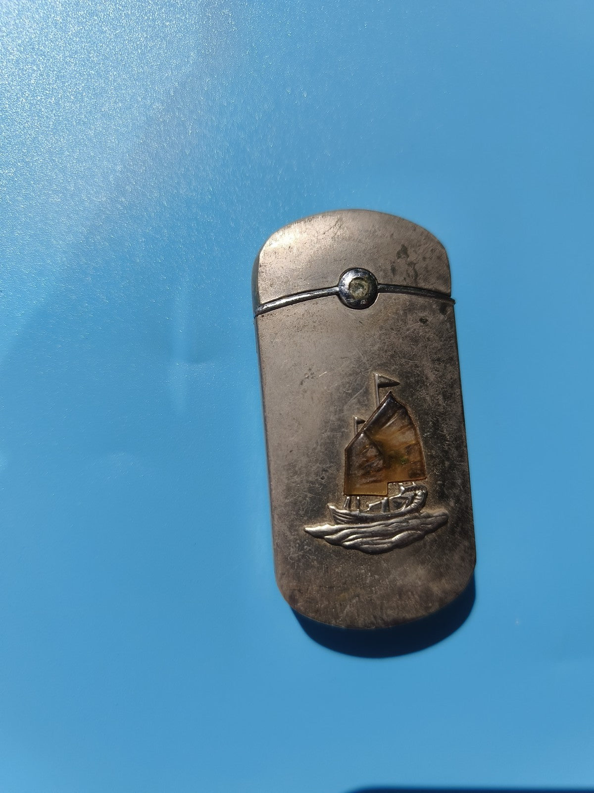 Ancien briquet publicitaire bateau relief, métal argenté, à restaurer
