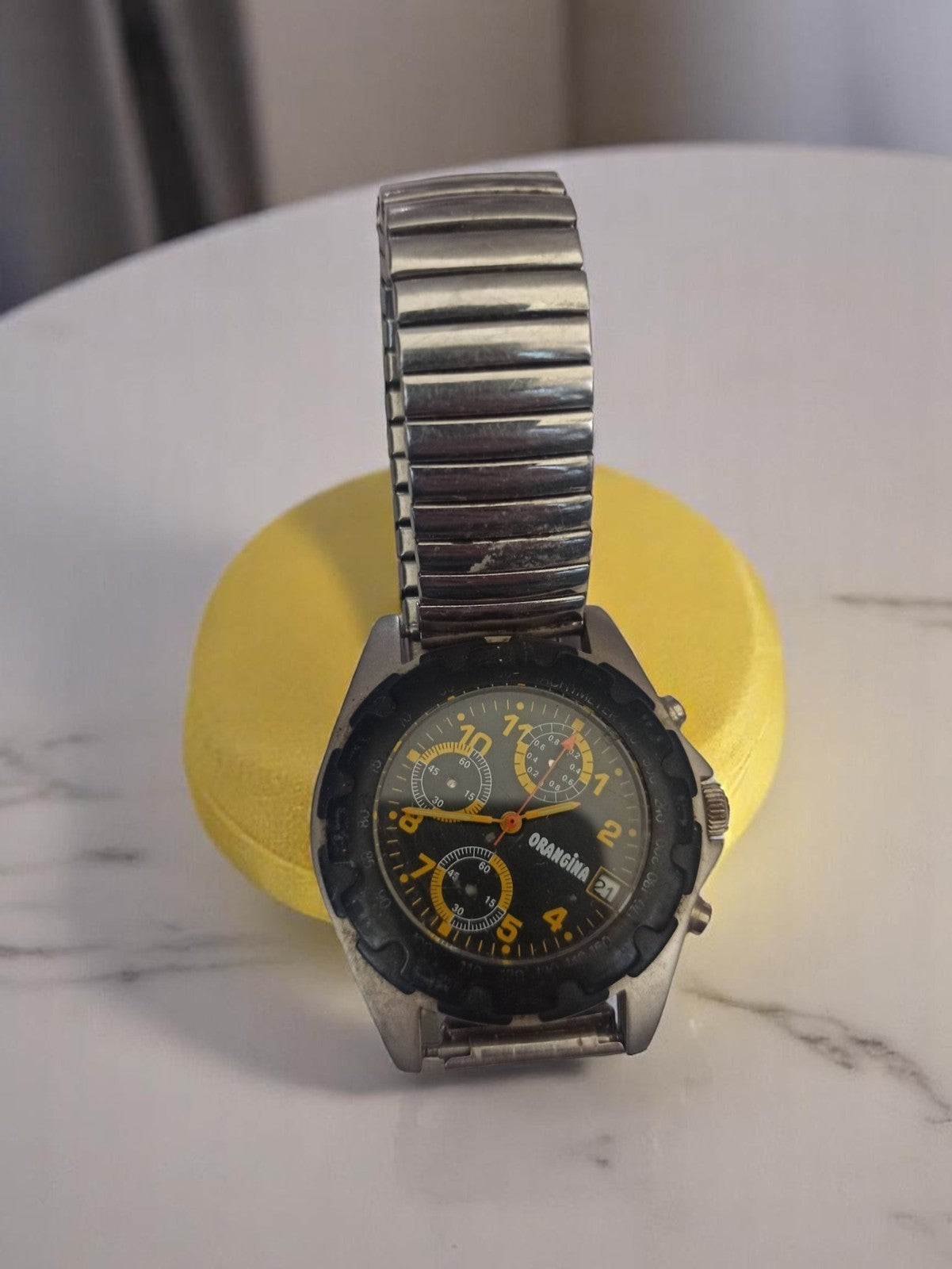 Montre publicitaire homme Orangina vintage, cadran noir, bracelet métal extensib
