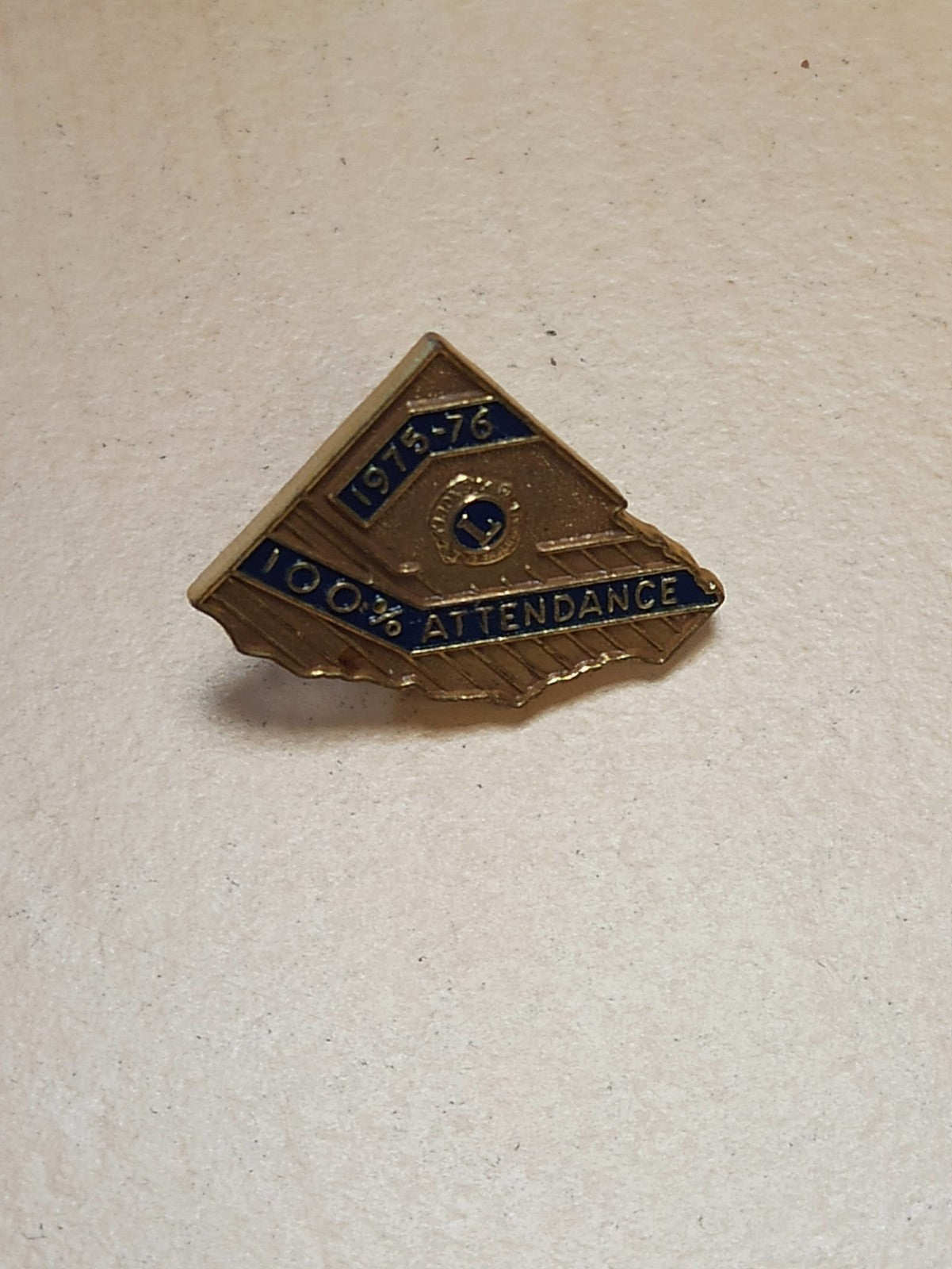 Pin's ancien Lions Club 1975-76, insigne vintage 100% attendance doré rétro