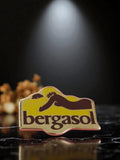 Pin's publicitaire vintage Bergasol émail logo rétro années 80 jaune marron