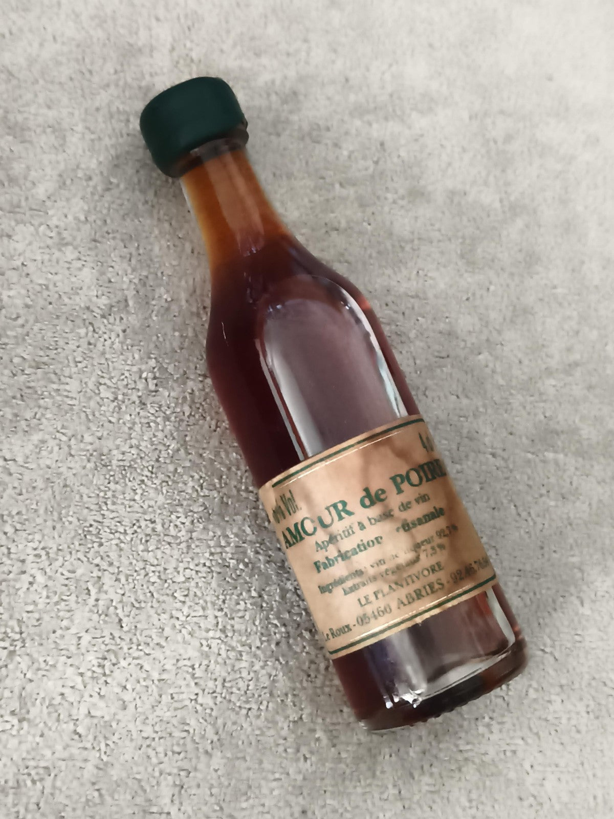 Miniature alcool L'Amour de Poire apéritif bouteille partiellement remplie