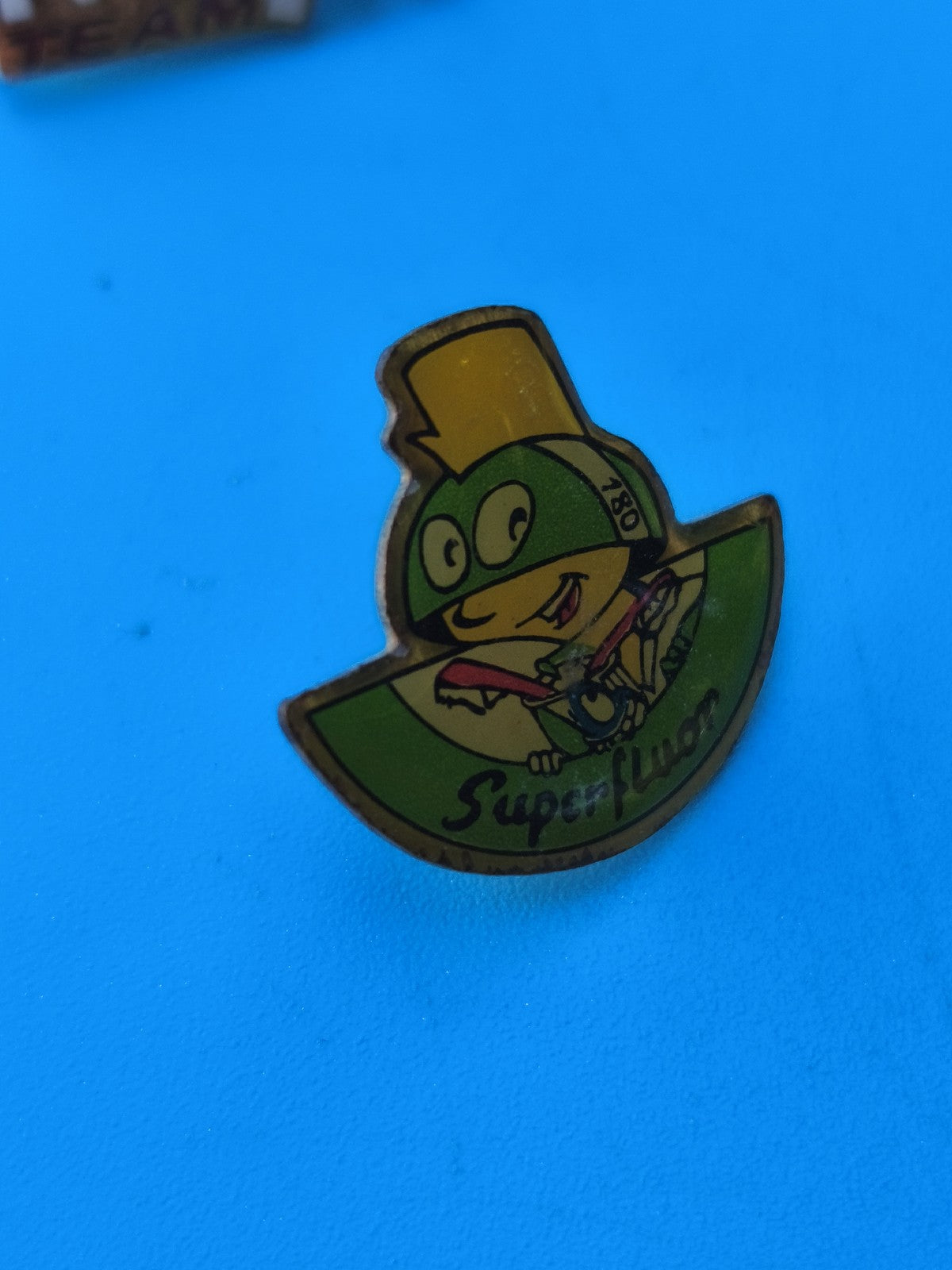 Pin's vintage Super Fluor personnage casque vert jaune collection rétro (Ref 8)