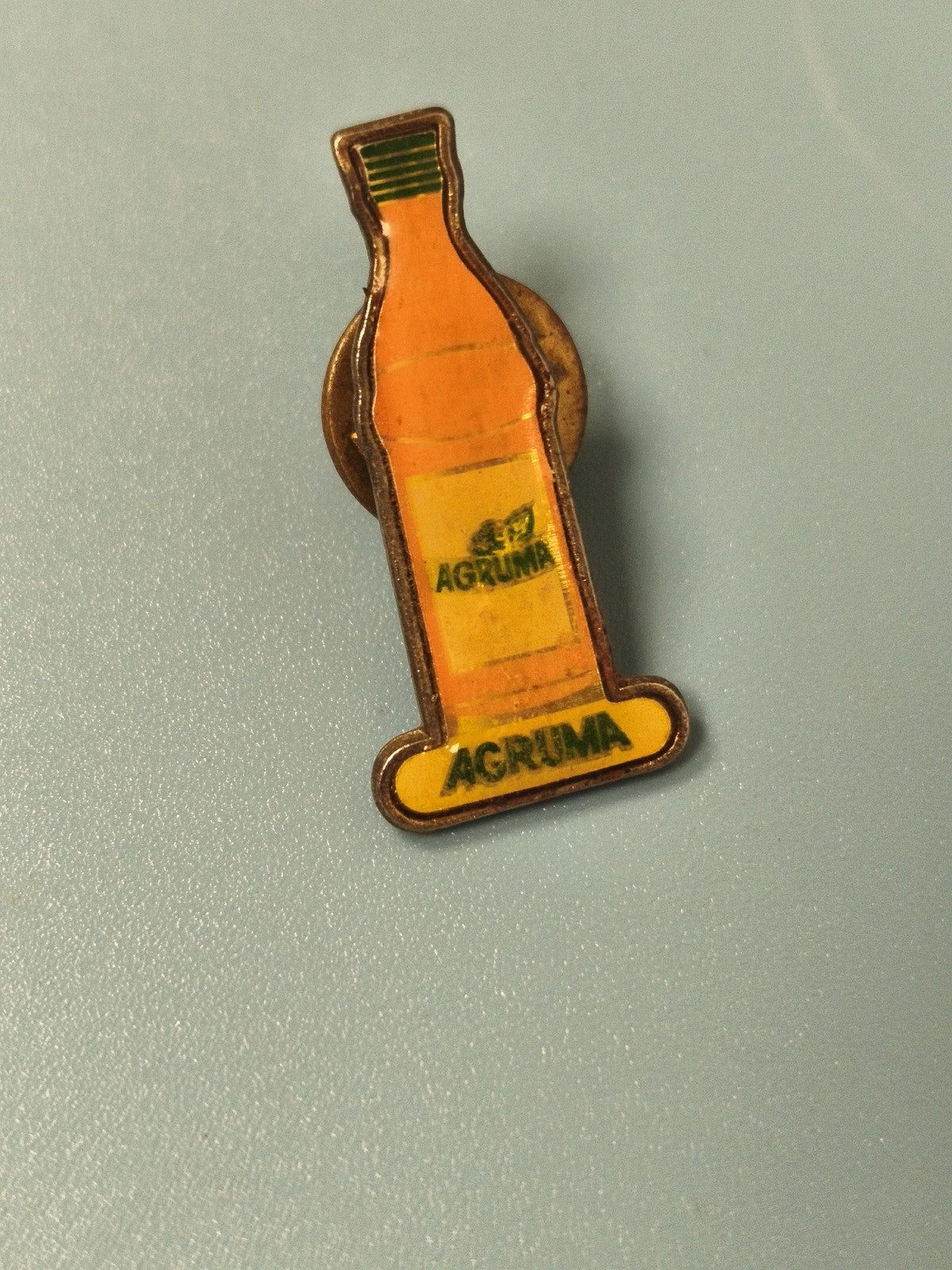 Pin's vintage Agruma bouteille boisson publicitaire jaune ancien collection
