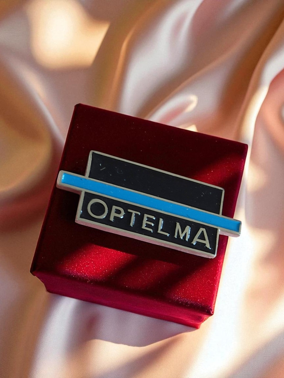 Pin's publicitaire vintage OPTELMA émail ? badge logo ancien rétro