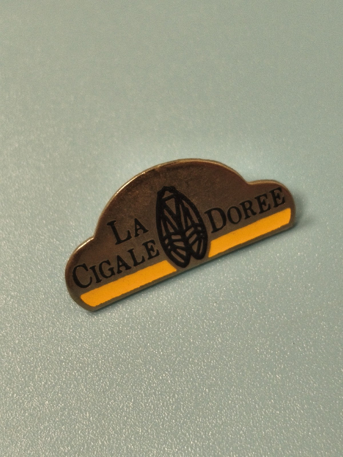 Vintage pin's La Cigale Dorée ancien, forme demi-lune, jaune et noir