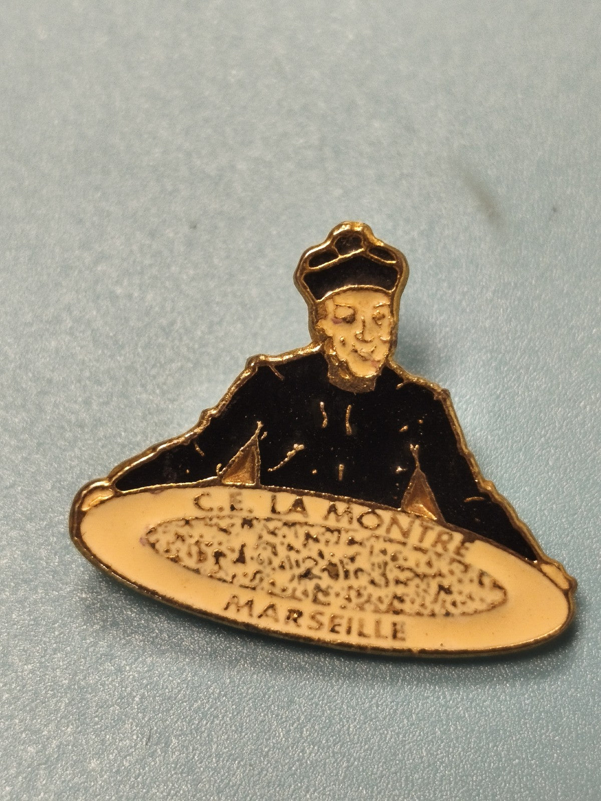 Pin's vintage Marseille C.E. La Montre personnage religieux émaillé ancien
