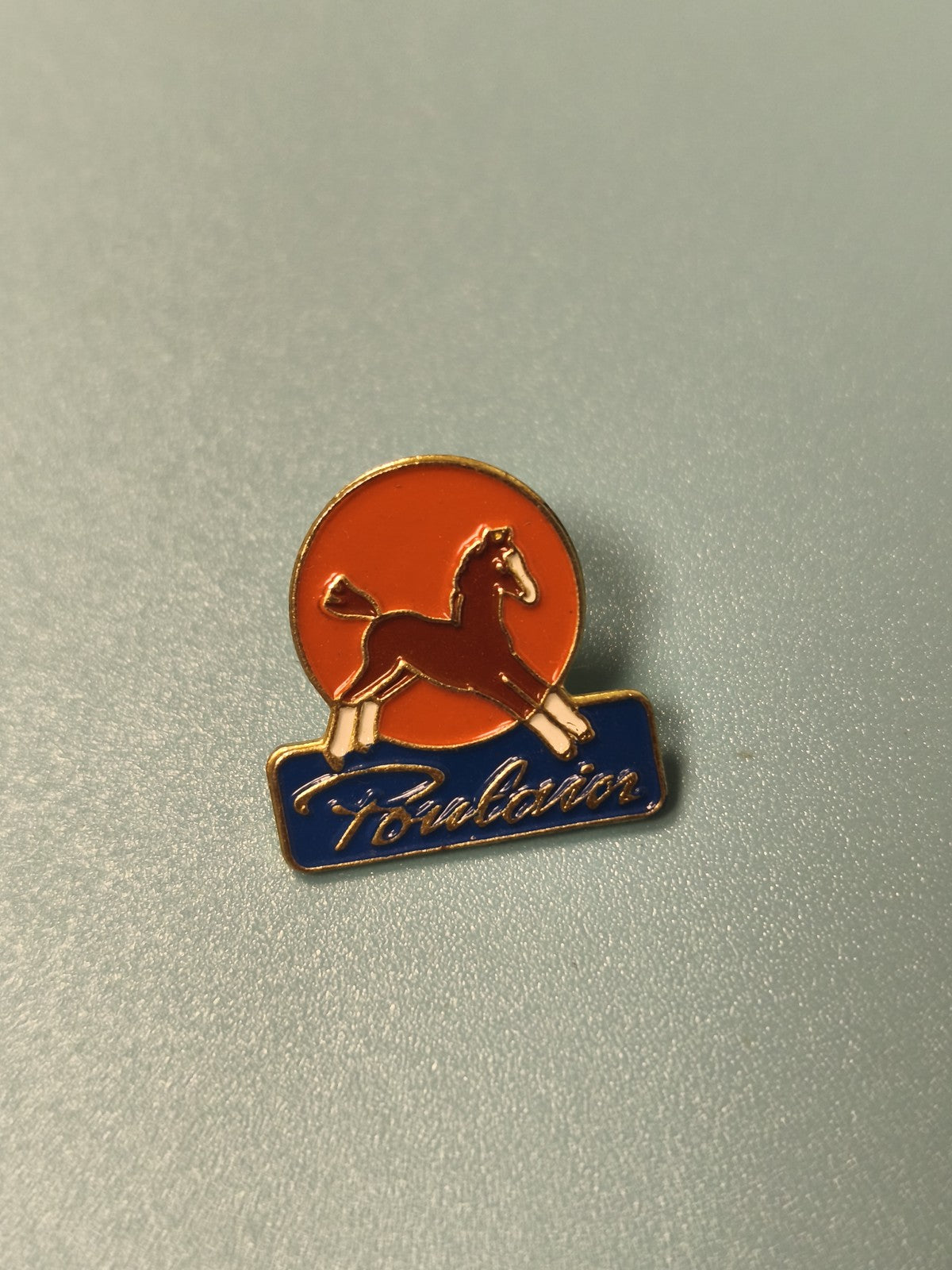 Pin's vintage Poulain cheval émaillé orange et bleu collection publicitaire