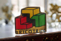 Pin's vintage Bricotruc logo rétro cubique rouge jaune vert rare