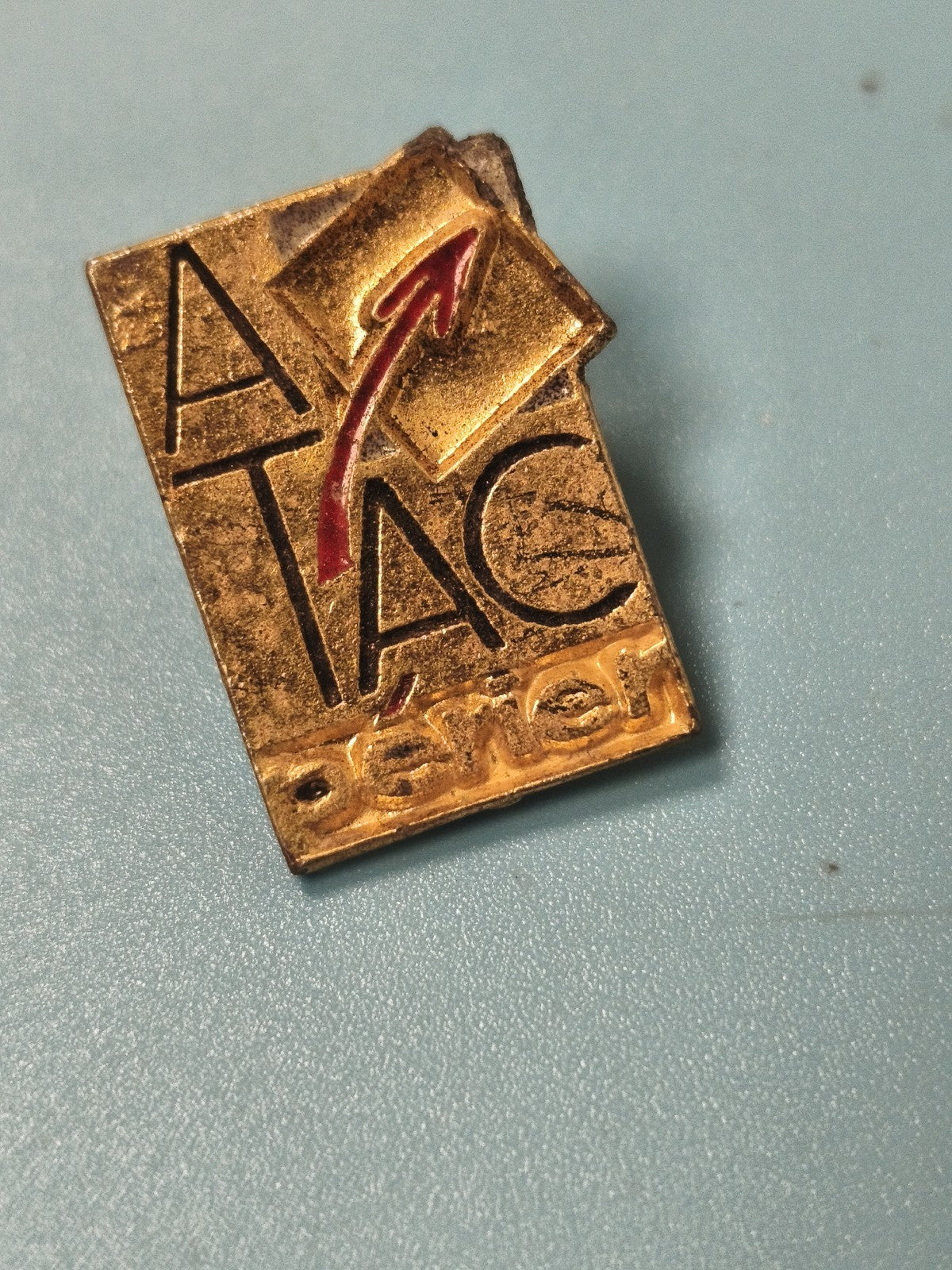 Vintage pin's ATAC Perrier doré logo flèche rouge rectangulaire (Ref 5)