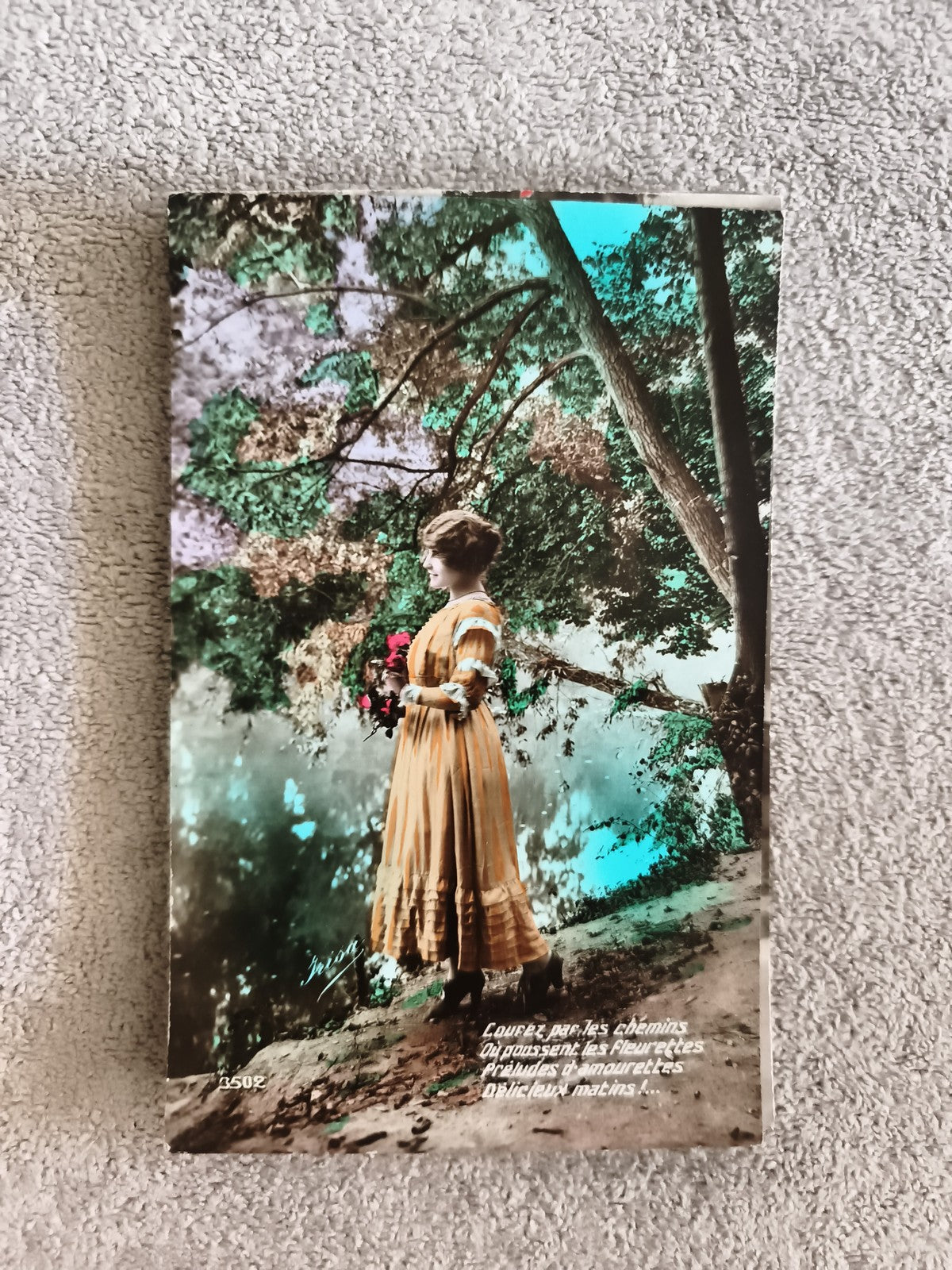 CPA femme robe jaune bouquet colorisé début XXe carte postale