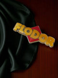 Pin's publicitaire vintage FLODOR en émail, logo jaune rouge, rare badge ancien