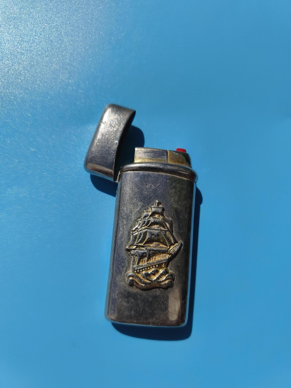 Ancien briquet publicitaire à clapet décor bateau relief, collection vintage